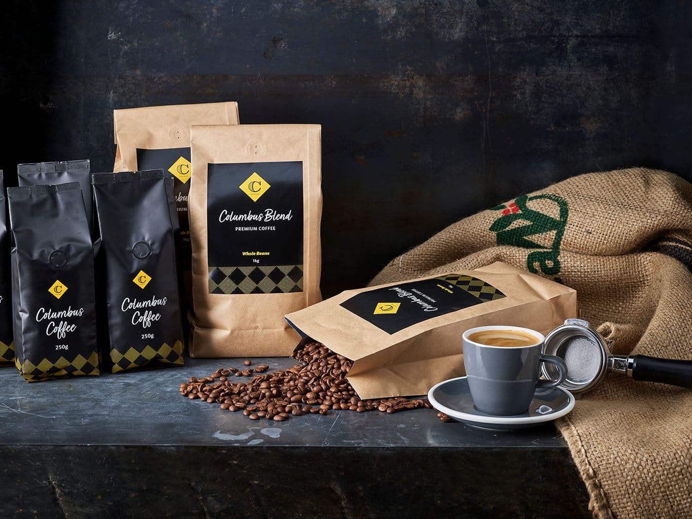 Retail bags of coffee beans with one lying down and coffee beans spilling out on the table