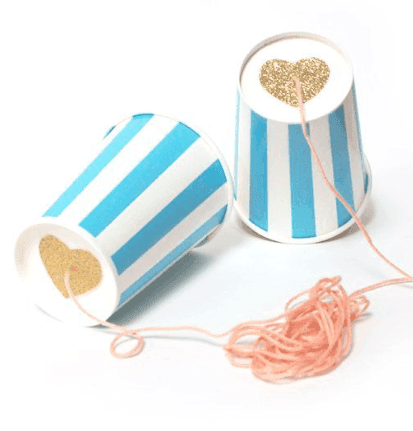 Two paper cups tied together with string to make a phone