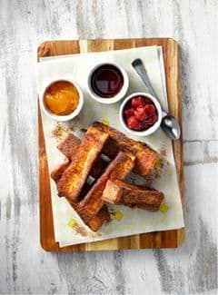 French toast sticks with berries and sauces in ramekins